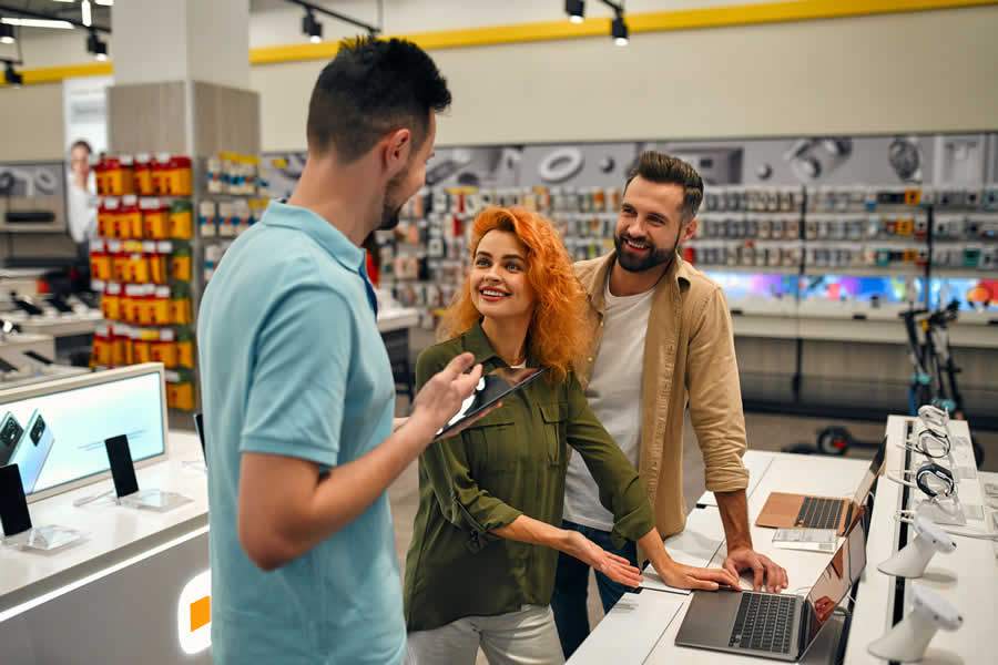 casal conversando com vendedor de computador em loja