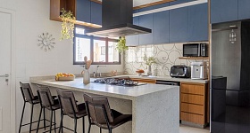 Neste projeto, o arquiteto Paulo Tripoloni brinca com a paleta cromática trazendo na marcenaria laminada um azul mineral que harmoniza com o granito branco-itaúnas escovado em destaque na bancada | Projeto: Atelier de Arquitetura Paulo Tripoloni | Foto: Rafael Renzo