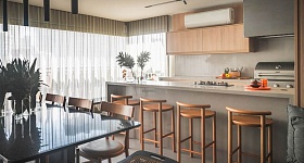   Neste projeto das arquitetas Danielle Dantas e Paula Passos, a península com banquetas é um convite à convivência, enquanto o home bar, a adega e a cervejeira reforçam o espírito festeiro da família. Com o suporte da churrasqueira, do cooktop e da coifa, tudo funciona de forma prática e integrada à sala de jantar, sem abrir mão do conforto | Projeto Dantas & Passos Arquitetura | Foto: Henrique Ribeiro