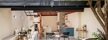 Para não ter que refazer todo o telhado original de barro, que já existia no projeto original, o arquiteto Bruno Moraes preservou e complementou com a estrutura metálica recoberta por vidro – decisão que ampliou a entrada de luz natural no espaço de convivência próximo à churrasqueira | Projeto BMA Studio | Foto: Guilherme Pucci