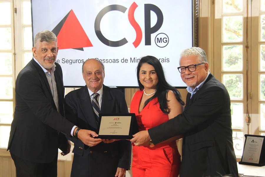 Andreia Cardoso, gerente comercial de Minas Gerais da Solidus Administradora, recebe placa de ades&atilde;o das m&atilde;os dos dirigentes do CSP-MG