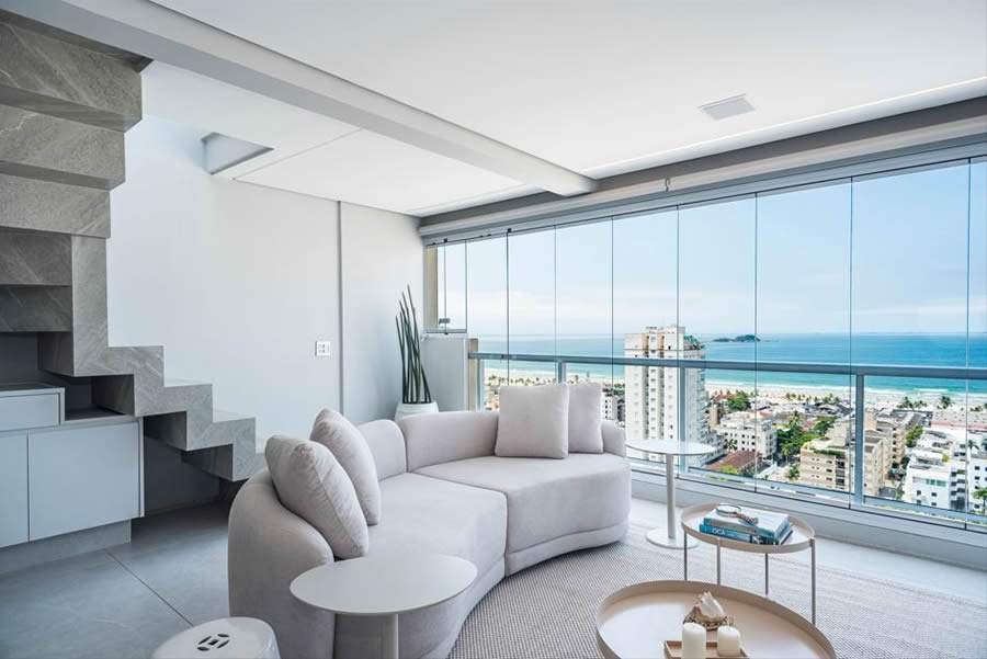 Neste projeto no Guarujá (litoral sul de São Paulo), os arquitetos Mariana Meneghisso e Alexandre Pasquotto maximizaram a incorporação do estar com a paisagem deslumbrante da Praia da Enseada para mostrar que o luxo é aproveitar a vista no conforto de casa | Projeto Meneghisso &amp; Pasquotto Arquitetura | Foto: Livia Kras