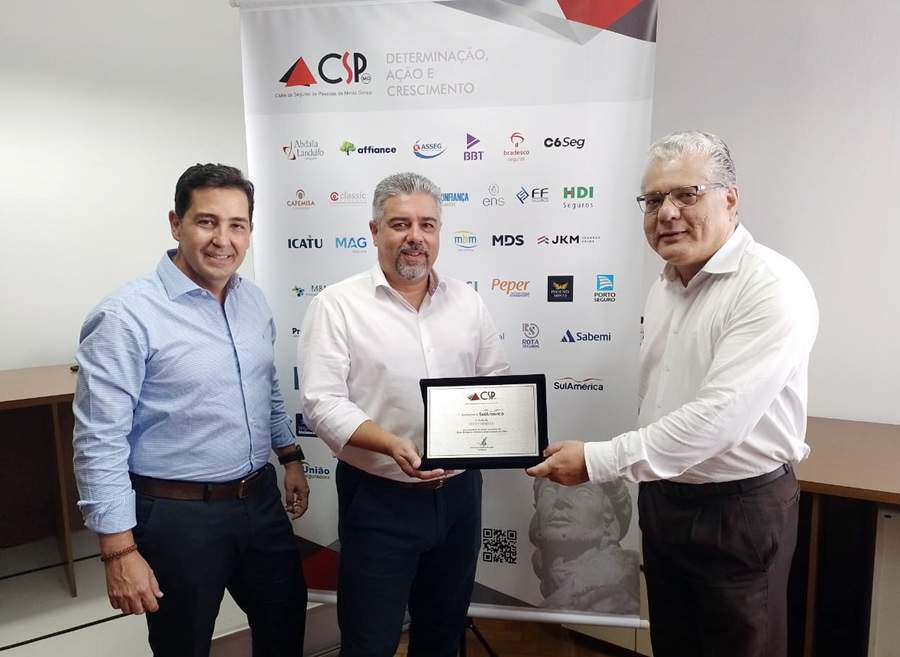 S&eacute;rgio Ricardo de Souza J&uacute;nior e Giuliano Alves Baeta (executivos da SulAm&eacute;rica) recebem a placa das m&atilde;os do presidente do CSP-MG, Jo&atilde;o Paulo Moreira de Mello
