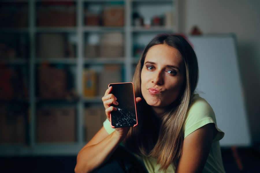 Pessoa segurando celular com a tela quebrada - Divulgação Grupo Fujioka