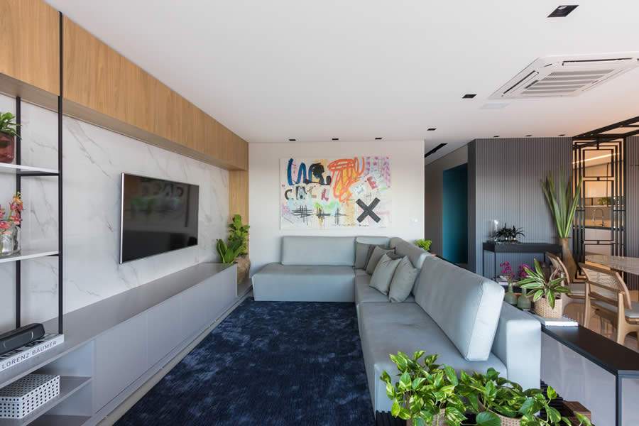 O espaçoso sofá em L foi a escolha para compor essa sala de estar projetada por Juliana Durando, do JADE Arquitetura e Design. A televisão fica bem colocada, atendendo ao ambiente. Foto: Luana Castro  
