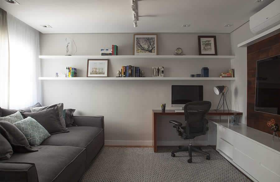Dupla fun&ccedil;&atilde;o: a sala de TV do apartamento tamb&eacute;m exerce a fun&ccedil;&atilde;o de escrit&oacute;rio para o home office. Por isso, a import&acirc;ncia da perfeita instala&ccedil;&atilde;o da infraestrutura para que os equipamentos da empresa contratada ofere&ccedil;am a melhor performance | Projeto Bruno Moraes e foto de Luis Gomes