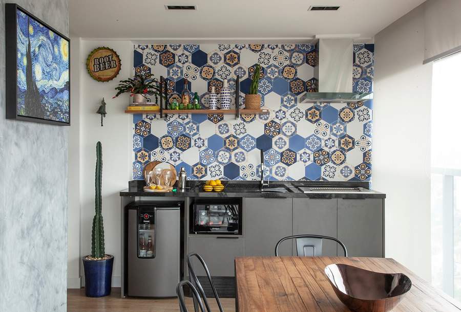 Para essa varanda gourmet, as arquitetas Bianca Tedesco e Viviane Sakumoto apostaram no ladrilho s e i sgonal colorido para dar vida à parede. Foto: Luis Gomes