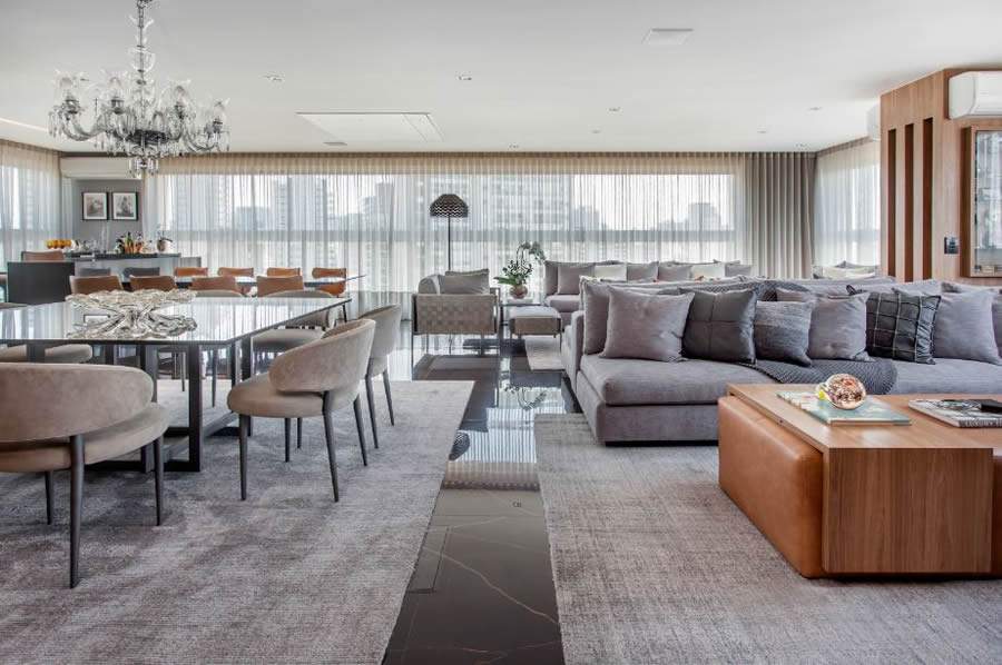 Em um s&oacute; &acirc;ngulo, &eacute; poss&iacute;vel visualizar a integra&ccedil;&atilde;o da &aacute;rea social abundantemente iluminada naturalmente pelas esquadrias de vidro do im&oacute;vel. A escolha dos tons proveu as sensa&ccedil;&otilde;es de continuidade e amplitude ao ambiente | Projeto de Dantas &amp; Passos Arquitetura | Foto: Edu Pozella