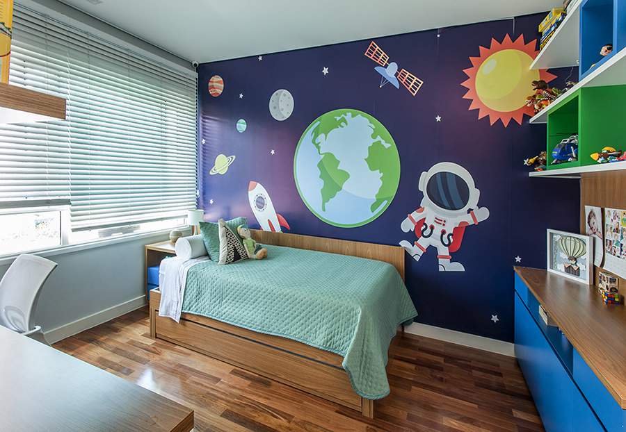 Ieda e Carina Korman, &agrave; frente do escrit&oacute;rio Korman Arquitetos, assinaram esse dormit&oacute;rio para uma crian&ccedil;a que sonha em ser astronauta. Um grande adesivo de parede ressalta essa paix&atilde;o de forma l&uacute;dica e pr&aacute;tica e, na marcenaria, nichos coloridos organizam os brinquedos, deixando tudo &agrave; m&atilde;o| Foto: Eduardo Pozella