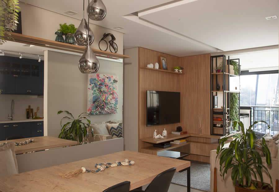 O m&oacute;vel em marcenaria armazena e camufla todos os fios el&eacute;tricos e aparelhos eletr&ocirc;nicos. As prateleiras colocadas na estrutura em serralheria servem como pequena adega de vinhos. Foto: Lu&iacute;s Gomes