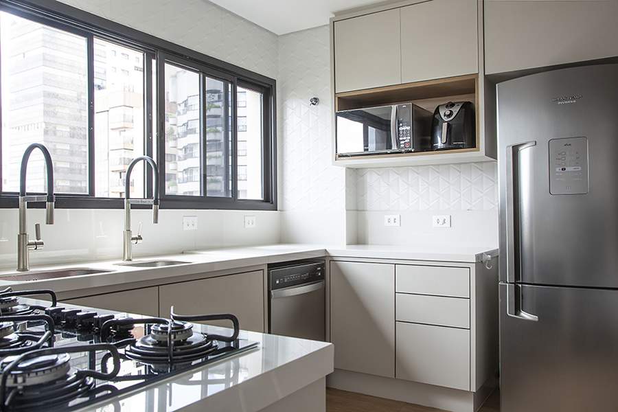 Neste projeto realizado pela arquiteta Carina Dal Fabbro, o ambiente conta com arm&aacute;rios generosos dentro de uma marcenaria com contempor&acirc;nea e os puxadores embutidos. A profissional apostou em uma paleta de cores com tons cl&aacute;ssicos | Foto: Luis Gomes