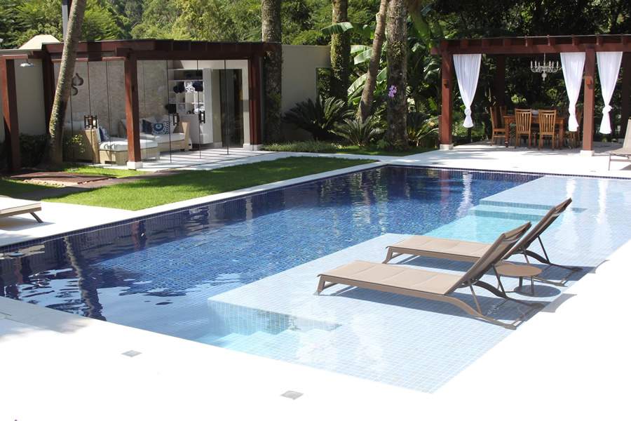 Nesse projeto, Cezar Scarpato optou por espregui&ccedil;adeiras na parte rasa da piscina, ao passo que o gazebo abrigou uma mesa e cadeiras perfeitas para refei&ccedil;&otilde;es ao ar livre