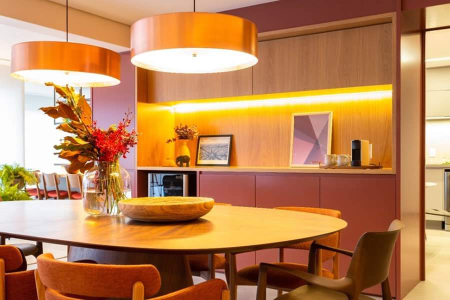 No projeto assinado pelas arquitetas do Studio Tan-gram, o momento de degustar uma das bebidas mais antigas do mundo foi enaltecida em uma posi&ccedil;&atilde;o especial: no nicho de marcenaria que acompanha o buffet. O charme fica para a luz de LED, que evidencia esse prazer dos moradores | Foto: Est&uacute;dio S&atilde;o Paulo