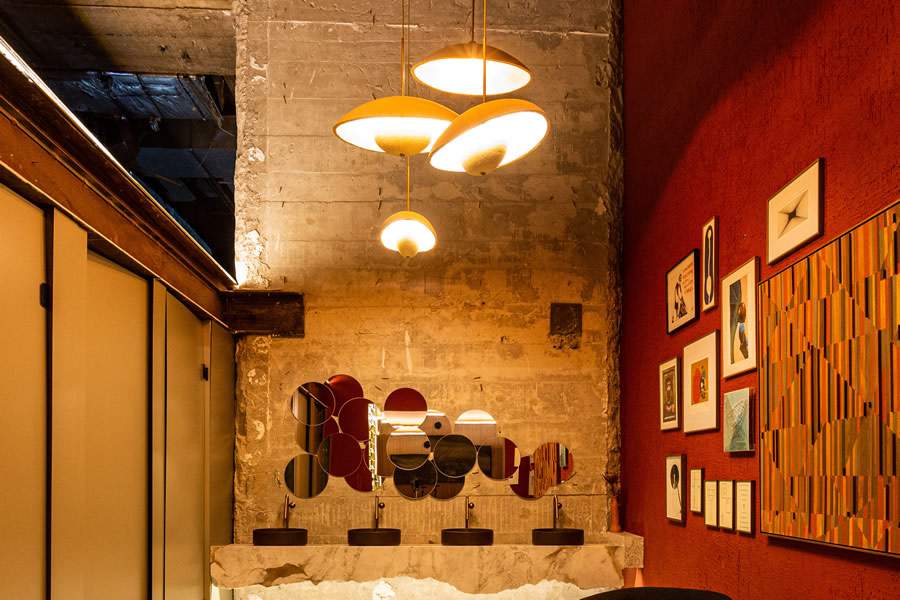 Banheiro Sincr&eacute;tico, por Isadora Araujo. No amplo p&eacute;-direito, o jogo de luzes com as lumin&aacute;rias produzidas com mic&eacute;lio | Foto: Mariana Camargo