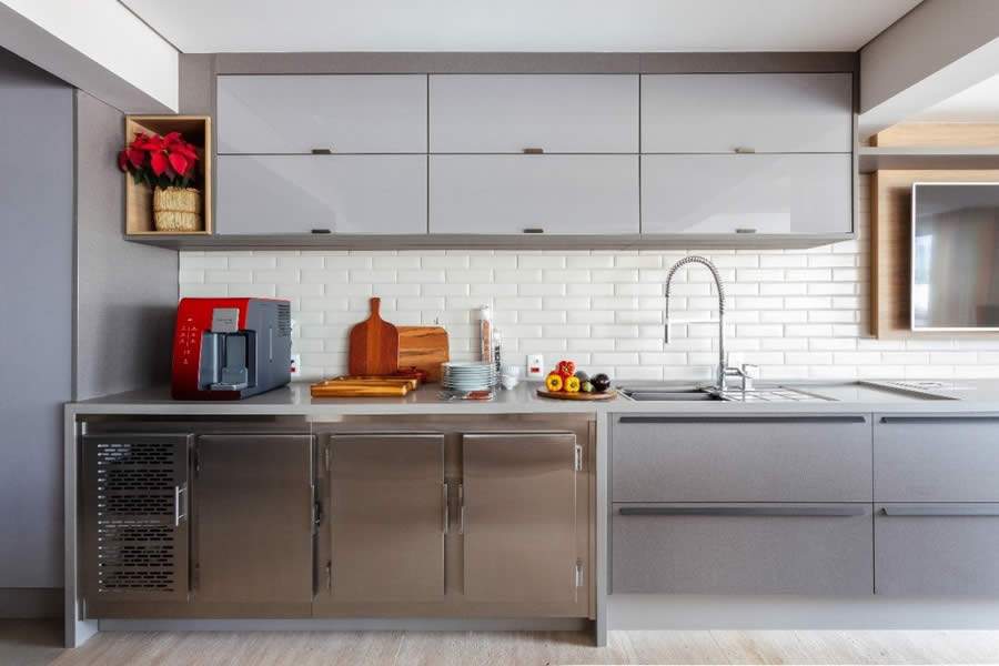 Neste projeto assinado pelo escrit&oacute;rio Dantas &amp; Passos Arquitetura, as profissionais e s&oacute;cias Paula Passos e Danielle Dantas apostaram em uma marcenaria cinza para os arm&aacute;rios inferiores e superiores. O balc&atilde;o refrigerado, todo em a&ccedil;o inox, acompanha o predom&iacute;nio da cor | Foto: Maura Mello