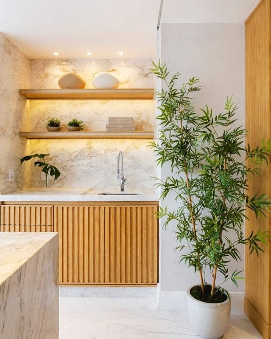 Na &aacute;rea da cozinha, tanto a bancada da pia, revestimento da parede e a ilha, foram revestidos pelo M&aacute;rmore Matarazzo. A suavidade de sua base branca acentuou-se com o efeito ripado, em tonalidade clara, da marcenaria presente no projeto assinado pelos arquitetos Renata Iervolino e Eduardo Tambellini | Projeto Etri Arquitetos | Foto: Leandro Furini