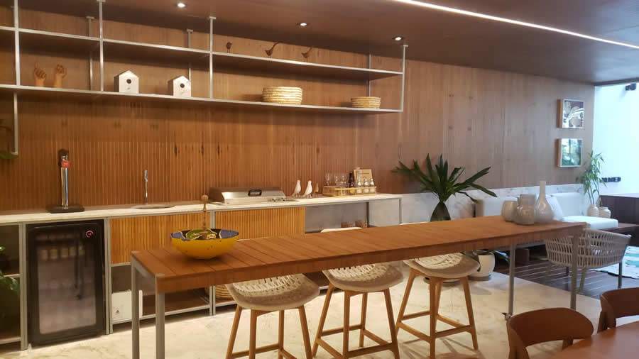 J&aacute; no decorado do Opus Penthouse, L&eacute;o Romano aposta no ripado em tons escuros nas paredes, teto e parte do piso. Para dar contraste e leveza, traz mobili&aacute;rio e acess&oacute;rios em tons claros - Raquel Pinho