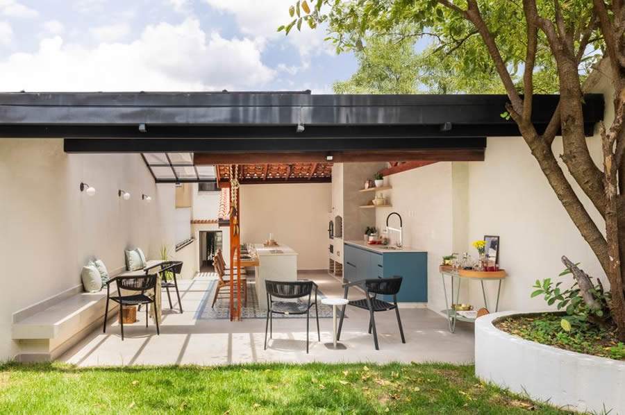 Para n&atilde;o ter que refazer todo o telhado original de barro, que j&aacute; existia no projeto original, o arquiteto Bruno Moraes preservou e complementou com a estrutura met&aacute;lica recoberta por vidro &ndash; decis&atilde;o que ampliou a entrada de luz natural no espa&ccedil;o de conviv&ecirc;ncia pr&oacute;ximo &agrave; churrasqueira | Projeto BMA Studio | Foto: Guilherme Pucci