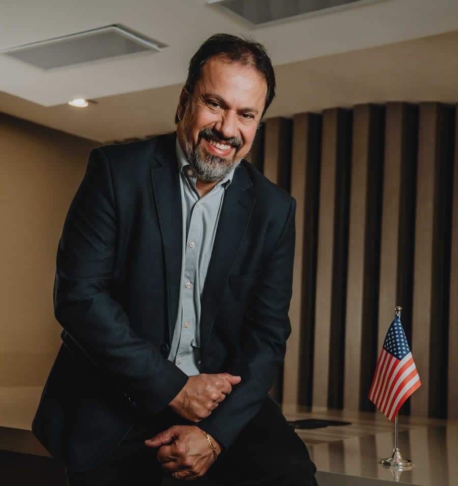 Renato sentado na mesa sorrindo