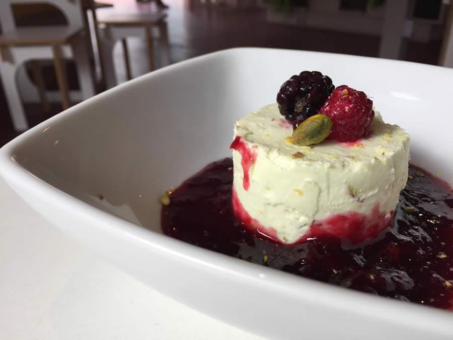 Cheesecake de limão siciliano e pistache com calda de frutas vermelhas